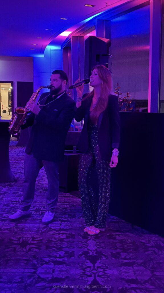 Sängerin, DJ und Saxophonist der DJ Plus Entertainment Show begeistern 200 Gäste beim BRZ Mittelstand Forum 2025 im Andel’s Hotel Berlin mit moderner Live-Musik und Partyhits.
