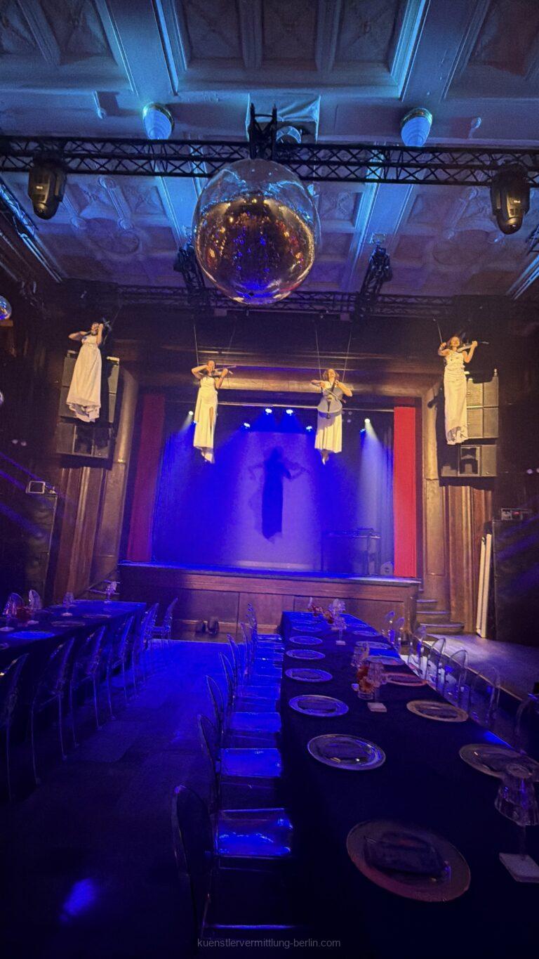 Four flying e-violinists perform modern crossover music above the guests' heads at an exclusive event in Zurich.