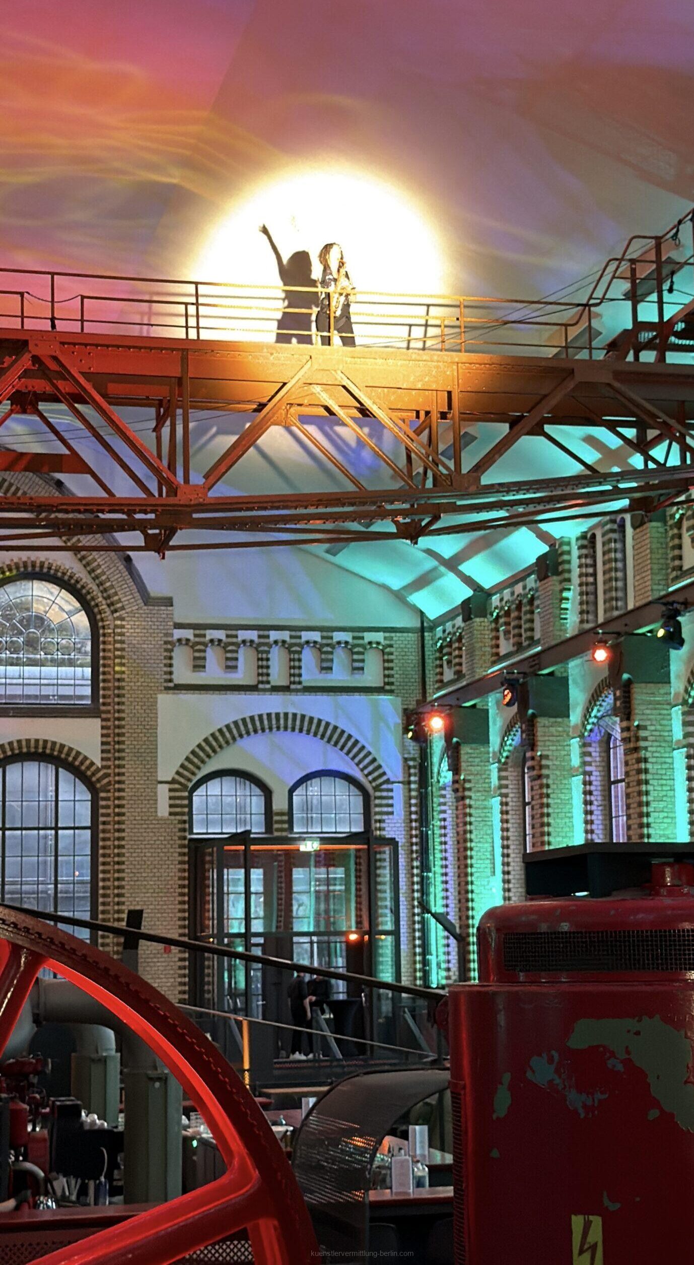 A flying saxophonist plays live music above the heads of the guests at Wasserwerk Berlin.