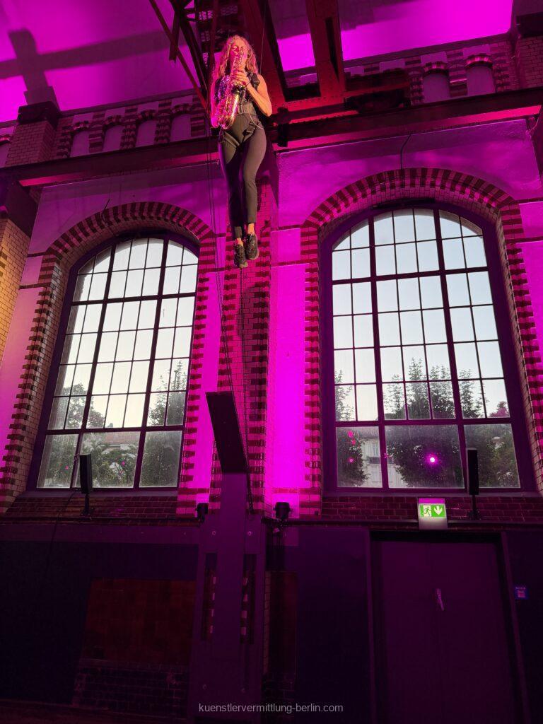 A flying saxophonist plays club hits on the historic turbine wheels of the Berlin Waterworks.