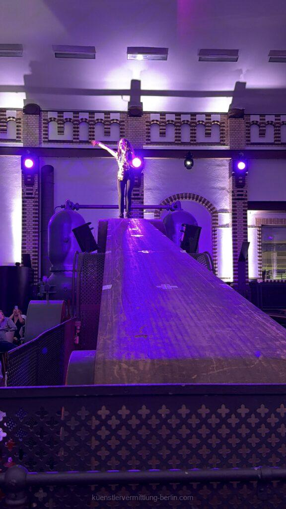 A flying saxophonist plays live music above the heads of the guests at Wasserwerk Berlin.